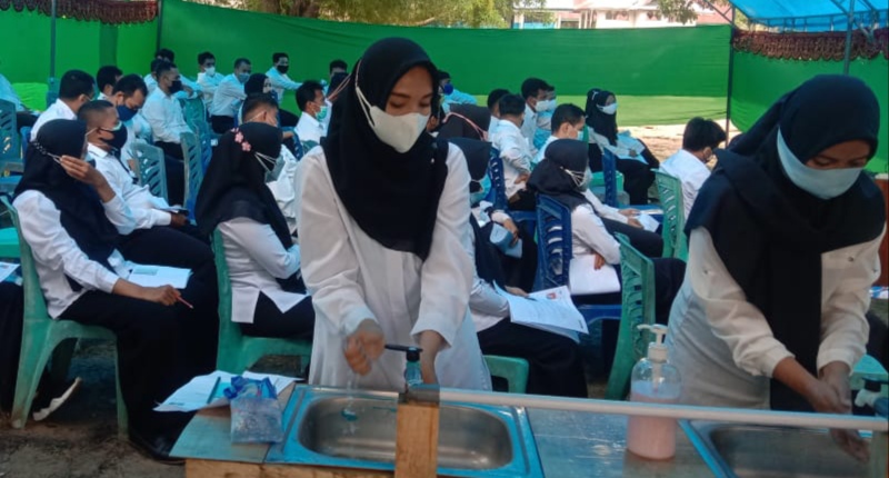 Peserta tes SKD CPNS Muna Barat mencuci tangan di tempat antrian pelaksanaan tes. (Foto: Hasan Jufri/SULTRAKINI.COM)