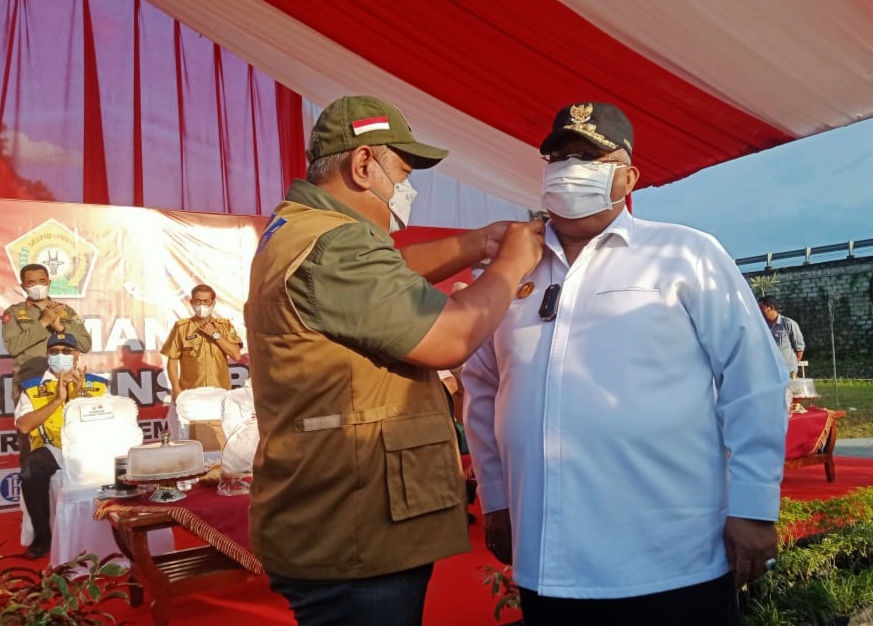 Penyemangat Pin tanda kehormatan oleh Kepala BNPB Pusat kepada Gubernur Sultra Ali Mazi (kanan). (Foto: WA Ode Ria Ika Hasana/SULTRAKINI.COM)