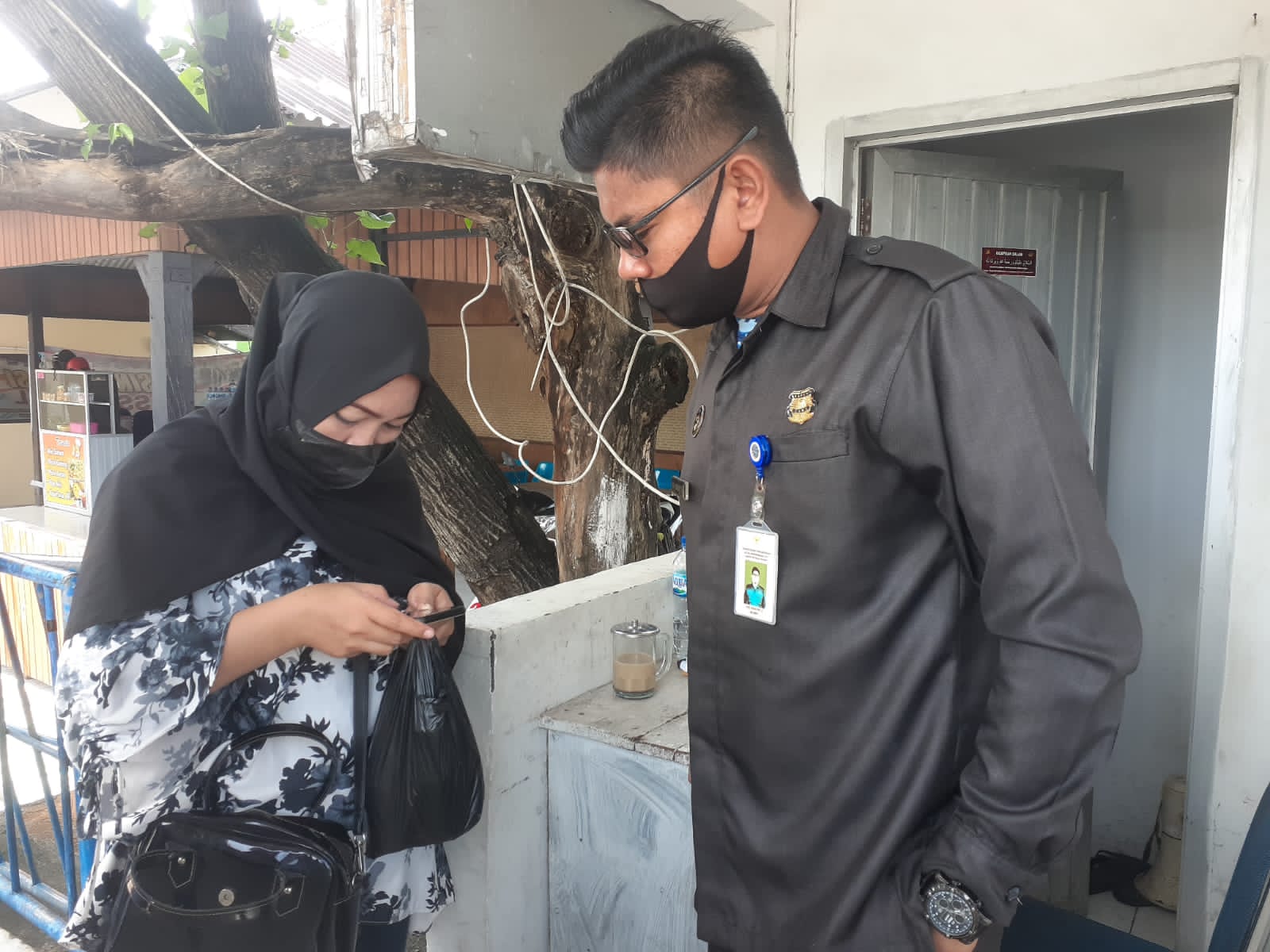 Plh Kepala KSOP Kelas II Baubau, Hasbi saat mengecheck status vaksin masyarakat yang hendak masuk di Pelabuhan Murhum. (Foto: Ist)