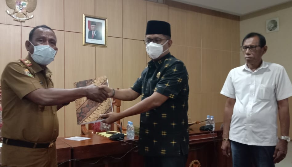 Penyerahan dokumen empat buah Perda dari Ketua DPRD Kabupaten Wakatobi Hamiruddin ke Sekda Wakatobi La Jumaddin. (Foto: Amran Mustar Ode/SULTRAKINI.COM)