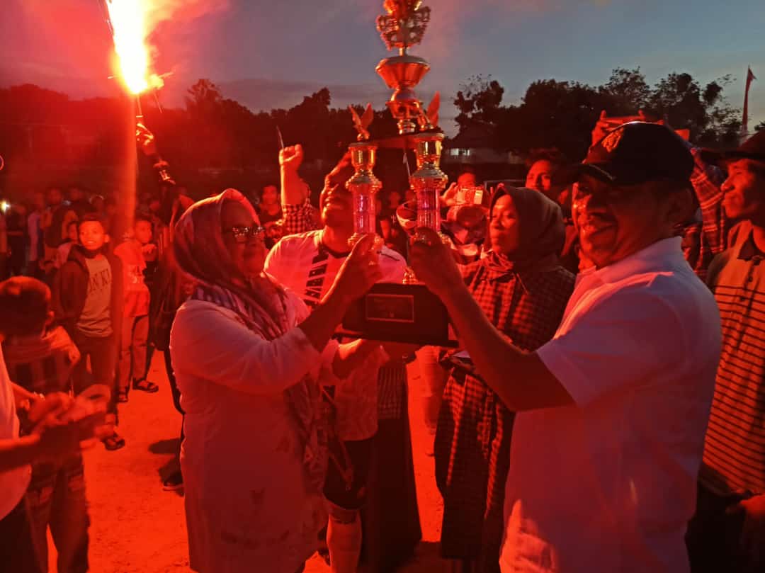 Wakil Bupati Muna, Bachrun Labuta memberikan piala bergilir Bola Mini Pasir Putih Cup IV kepada perwakilan Club Umi Moolo sebagai jawara, (Foto: LM Nur Alim/SULTRAKINI.COM)