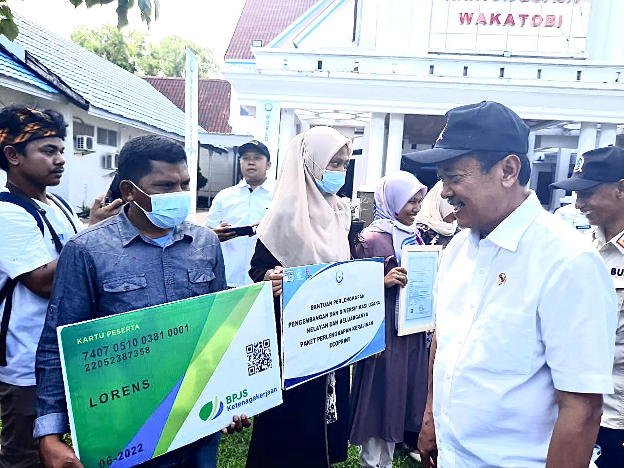 Menteri KKP, Sakti Wahyu Trenggono menyerahkan kartu kepesertaan BP Jamsostek kepada nelayan di halaman kantor Bupati Wakatobi. (Foto: Ist)