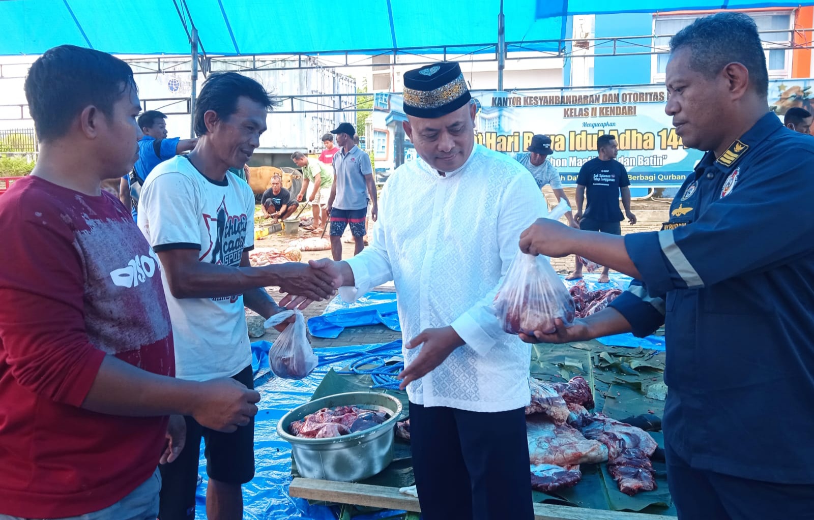 Kepala KSOP Kendari, Letkol Marinir Agus winarto (kedua dari kanan) menyerahkan daging kurban kepada buruh-buruh TKBM pelabuhan di Bungkutoko, Senin (11/7/2022) (Foto: Hasrul Tamrin/SULTRAKINI.COM)