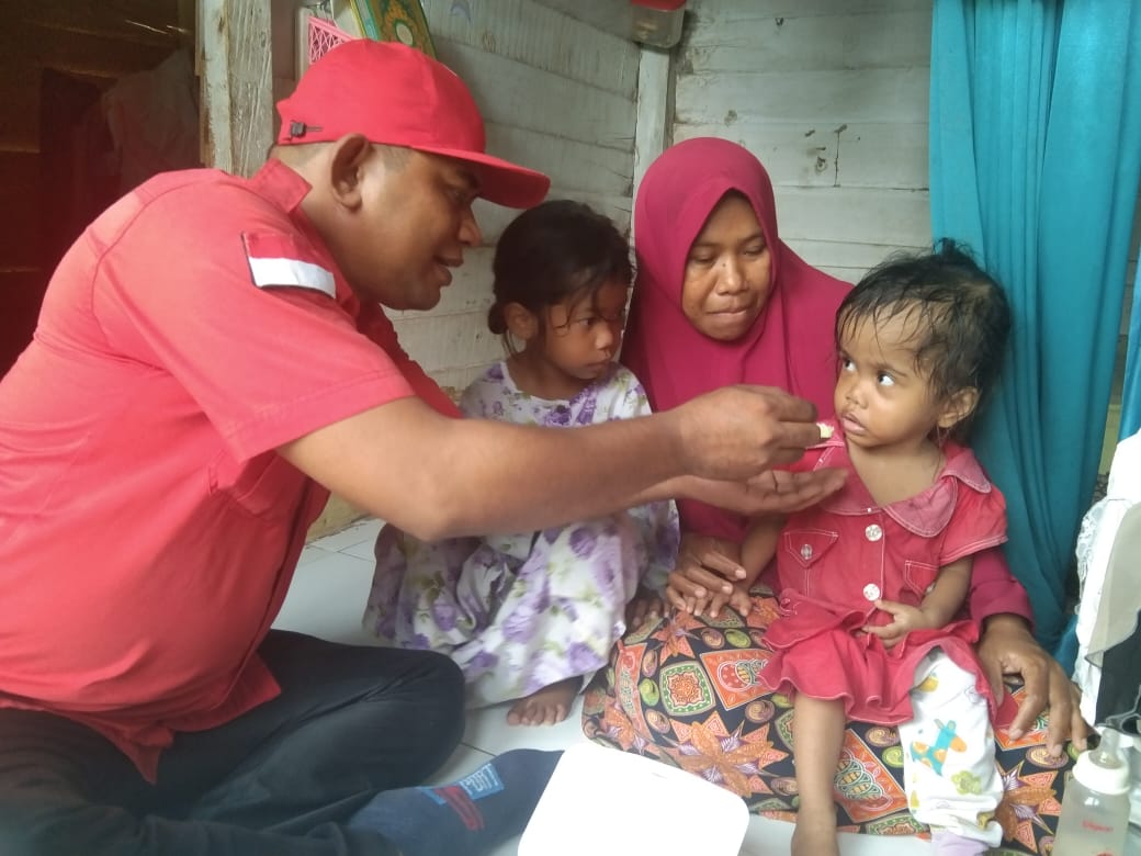 Ketua Dewan Pembina AP2 Sultra, LD. Hasanuddin Kansi saat menyuap Alma yang mangidap penyakit hidrosefalus. (Foto: Ist)