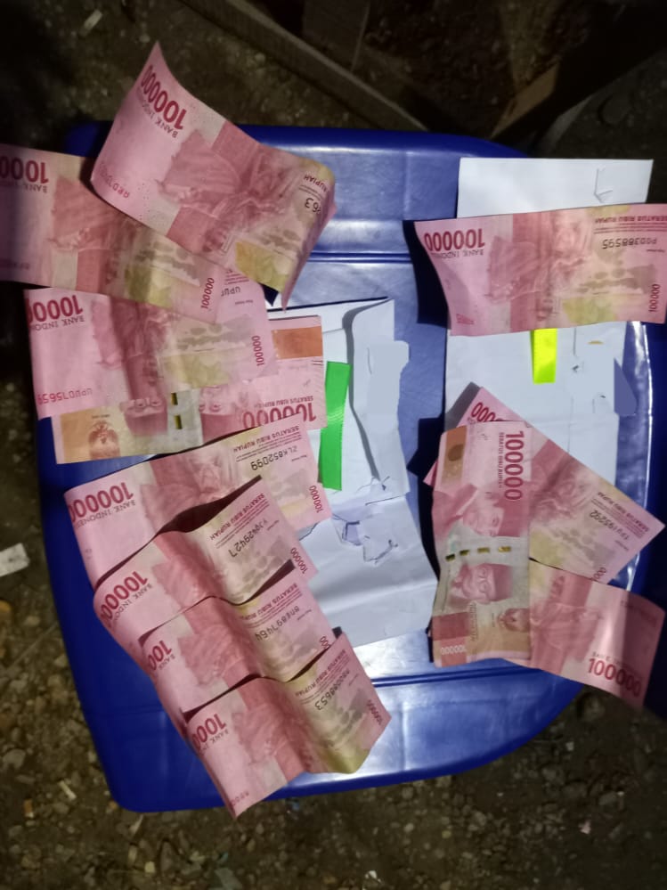 Sejumlah uang sebesar Rp400 ribu dan Rp700 ribu beserta amplopnya diduga diberikan oleh oknum polisi kepada warga di Desa Mokowu (Foto: Ist)