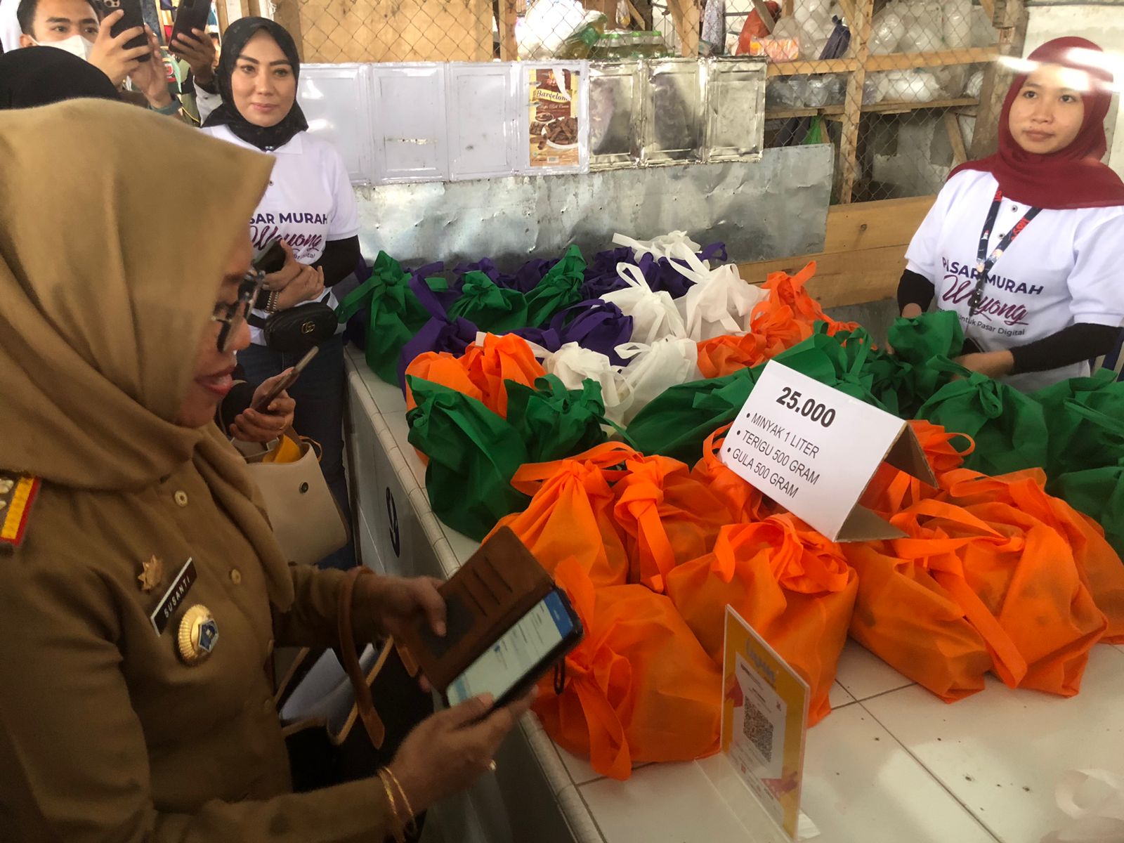 Asisten II Pemkot Kendari, Susanti melakukan transaksi digital pembelian di pasar Wayong, Kendari. (Foto: Ist)